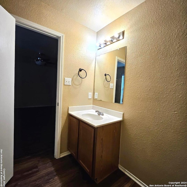 bathroom with hardwood / wood-style flooring, a textured ceiling, and vanity