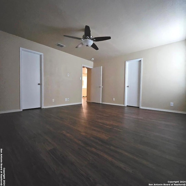 spare room with dark wood-type flooring and ceiling fan