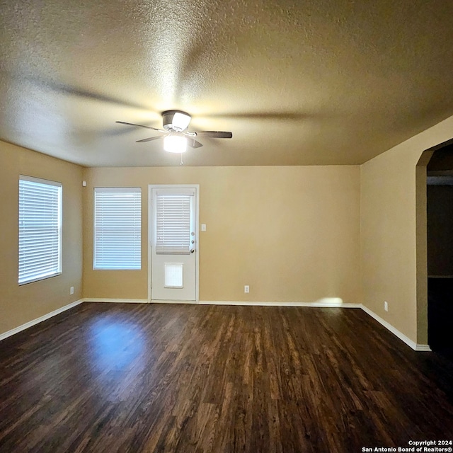 spare room featuring a textured ceiling, ceiling fan, and dark hardwood / wood-style floors