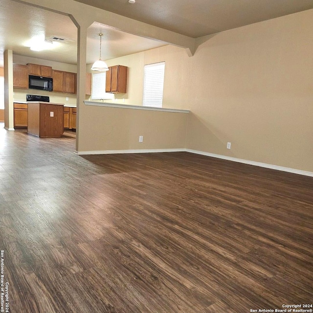 unfurnished living room with dark hardwood / wood-style flooring