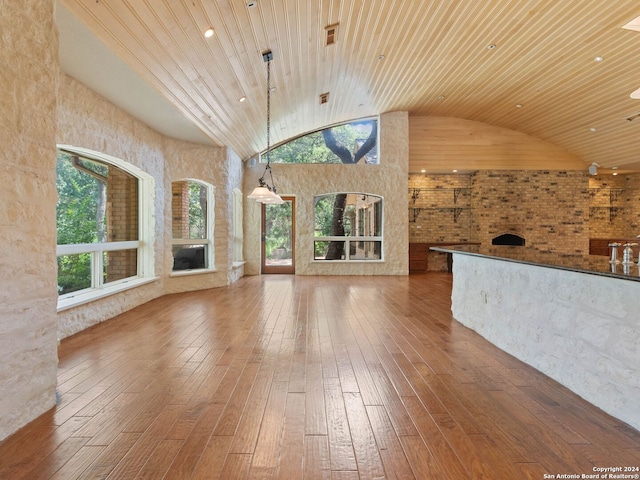 unfurnished living room with high vaulted ceiling, wood ceiling, and hardwood / wood-style floors