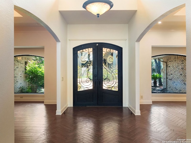 entrance foyer featuring crown molding, french doors, baseboards, and arched walkways