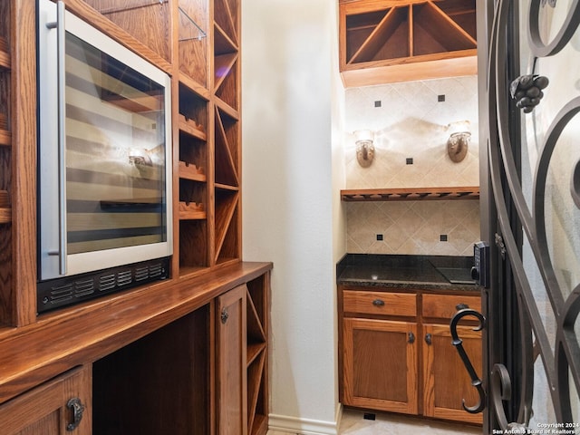 wine area featuring baseboards and wine cooler