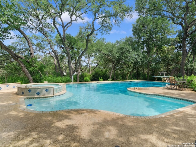 view of pool with a patio and a pool with connected hot tub