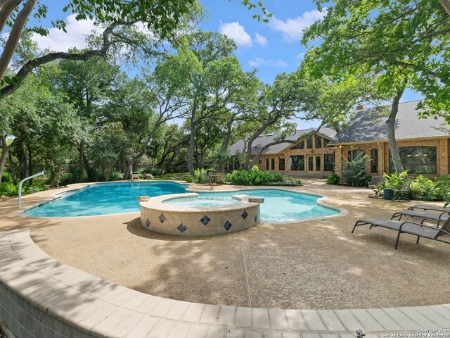 view of pool featuring a patio and a pool with connected hot tub