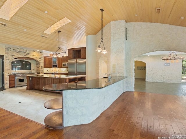 kitchen featuring an inviting chandelier, light wood-style flooring, arched walkways, wood ceiling, and built in appliances