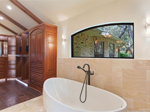 full bath with tile walls, recessed lighting, a freestanding tub, and lofted ceiling with beams