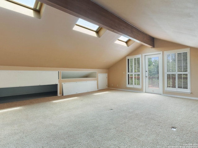 bonus room with vaulted ceiling with skylight, carpet flooring, and baseboards