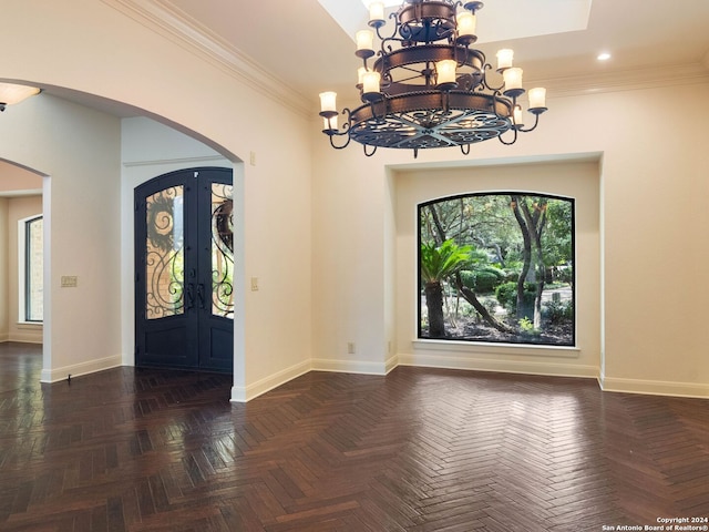 foyer featuring a chandelier, arched walkways, french doors, and baseboards