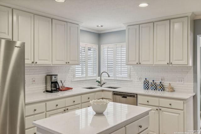 kitchen featuring tasteful backsplash, sink, stainless steel appliances, white cabinets, and crown molding