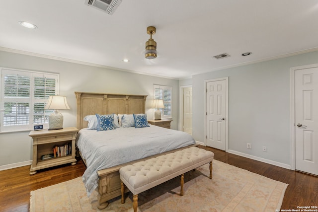 bedroom with crown molding, dark hardwood / wood-style flooring, and ceiling fan