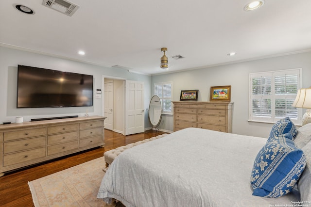 bedroom featuring crown molding and dark hardwood / wood-style flooring