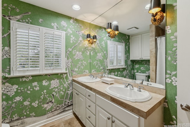 bathroom featuring toilet, vanity, tile patterned floors, and plenty of natural light