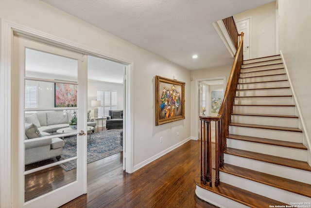 stairs with french doors, hardwood / wood-style flooring, and a textured ceiling