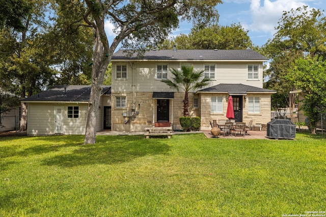 rear view of house featuring a yard and a patio