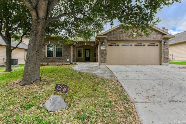 ranch-style house with a garage, a front lawn, and central air condition unit