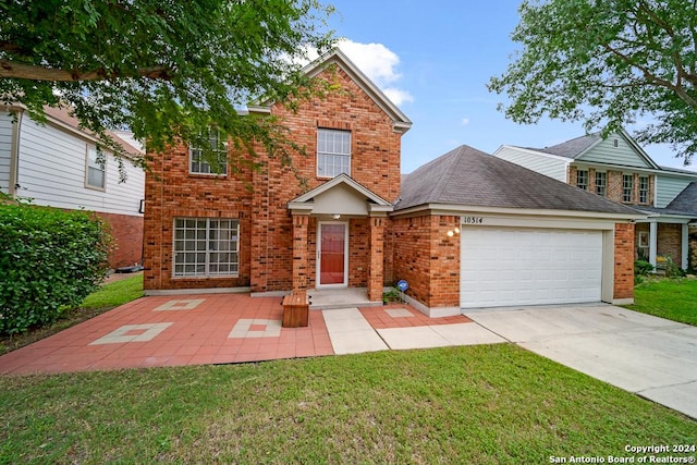 traditional home featuring a front yard, an attached garage, brick siding, and driveway