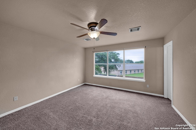 spare room with ceiling fan, carpet, and a textured ceiling