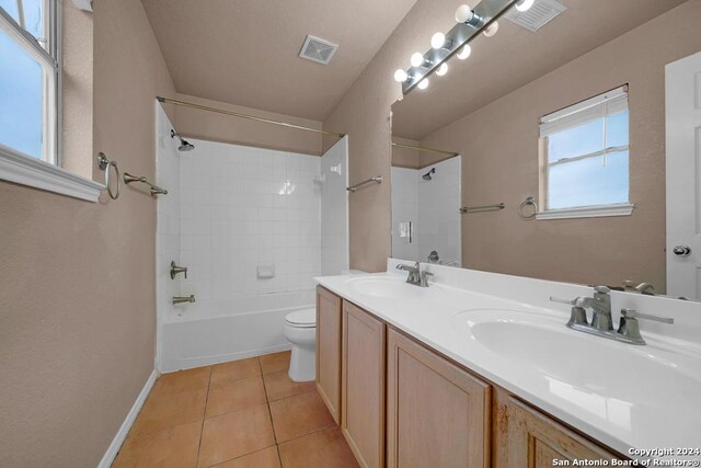 full bathroom with tile patterned flooring, toilet, tiled shower / bath combo, and vanity