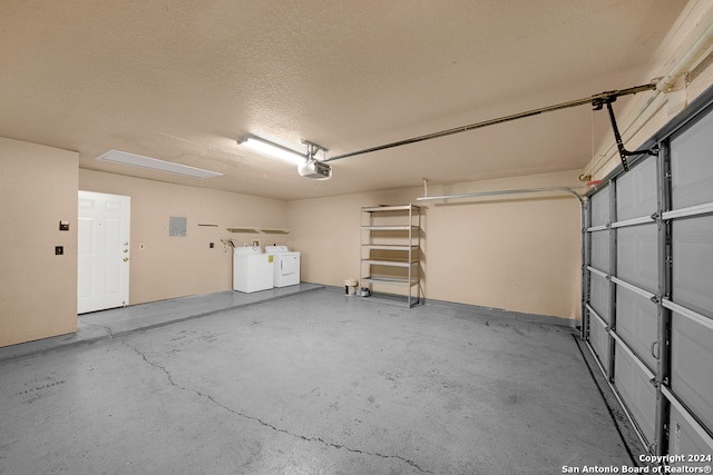 garage with independent washer and dryer and a garage door opener