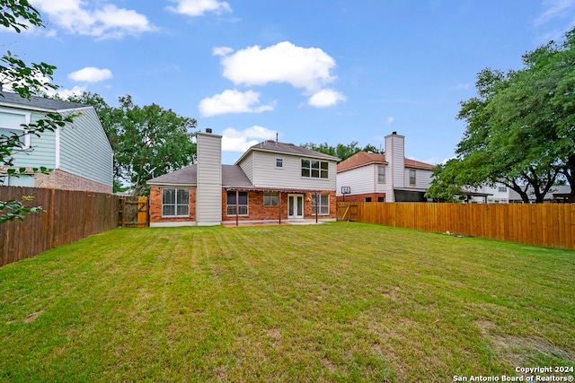 rear view of house with a yard and a patio