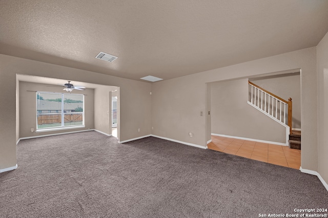 empty room with light carpet, a textured ceiling, and ceiling fan