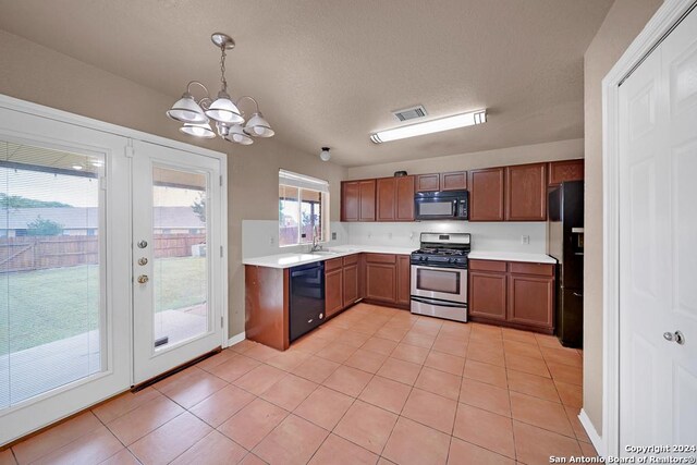 kitchen with an inviting chandelier, decorative light fixtures, sink, black appliances, and a textured ceiling