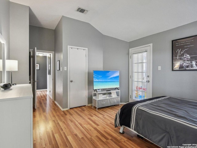 bedroom with lofted ceiling and light hardwood / wood-style flooring