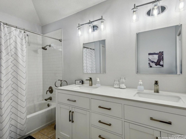 bathroom featuring a textured ceiling, vanity, shower / bath combo with shower curtain, and tile patterned flooring