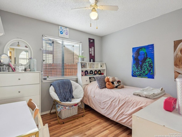 bedroom with a textured ceiling, light hardwood / wood-style flooring, and ceiling fan