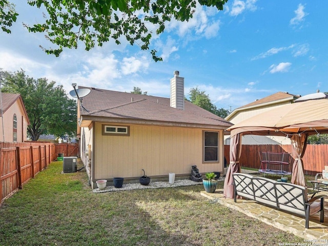 rear view of house featuring central AC, a gazebo, a yard, and a patio