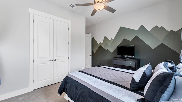 bedroom featuring light colored carpet, ceiling fan, and a closet