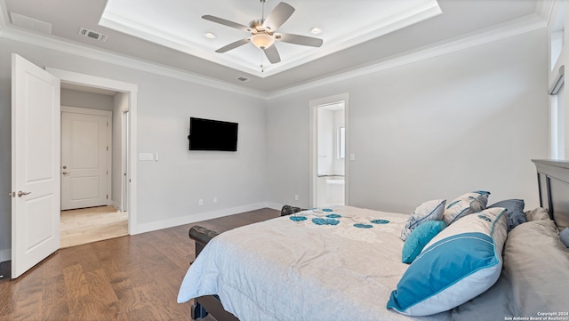 bedroom with ornamental molding, ceiling fan, dark hardwood / wood-style floors, and a tray ceiling