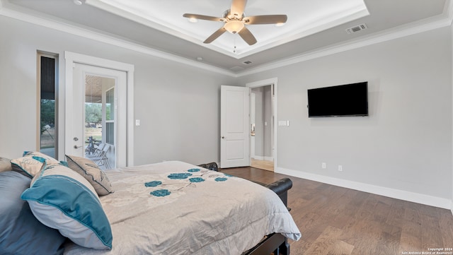 bedroom featuring a tray ceiling, access to outside, dark wood-type flooring, ceiling fan, and ornamental molding