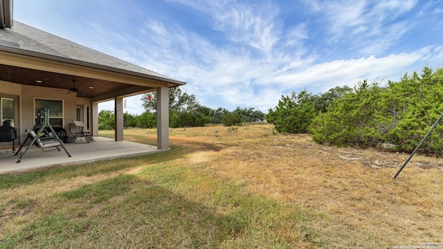 view of yard featuring ceiling fan and a patio area