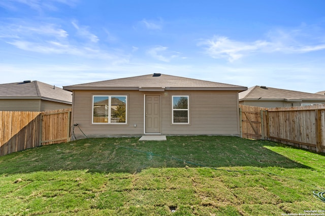 rear view of house featuring a lawn