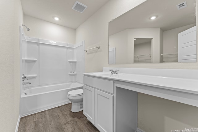 full bathroom with toilet, vanity, wood-type flooring, and washtub / shower combination