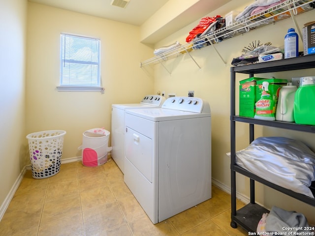 washroom featuring washing machine and clothes dryer and light tile patterned flooring