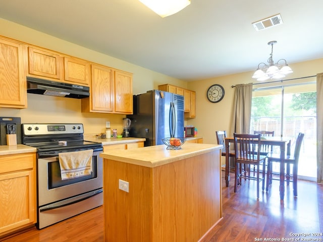 kitchen featuring stainless steel range with electric stovetop, hardwood / wood-style floors, a chandelier, a kitchen island, and black fridge