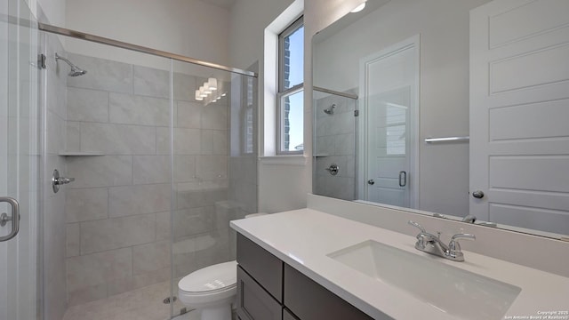 bathroom featuring vanity, toilet, an enclosed shower, and a healthy amount of sunlight