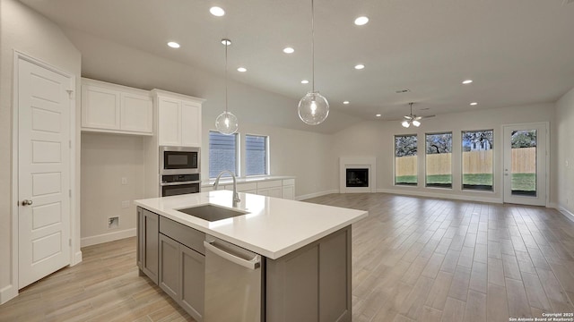 kitchen featuring stainless steel appliances, ceiling fan, sink, decorative light fixtures, and white cabinets