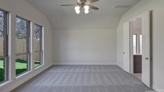 empty room with light carpet, vaulted ceiling, and ceiling fan