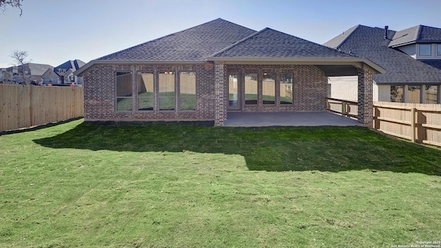 rear view of property with a lawn and a patio