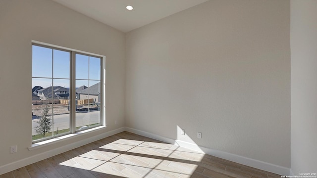 spare room featuring a wealth of natural light and light wood-type flooring