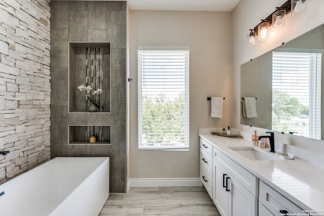 bathroom with a tub, vanity, and hardwood / wood-style flooring