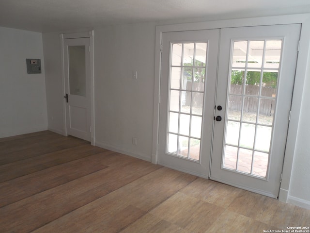 doorway to outside featuring a healthy amount of sunlight, hardwood / wood-style flooring, and french doors