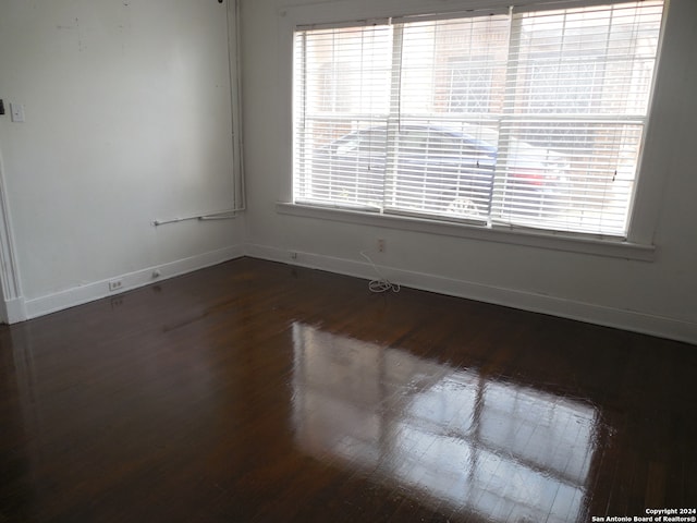 unfurnished room featuring dark hardwood / wood-style flooring and a healthy amount of sunlight