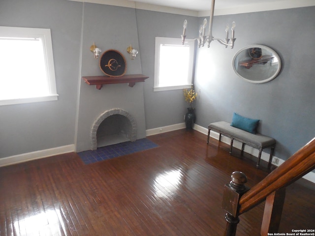 unfurnished living room with a fireplace, dark hardwood / wood-style floors, and an inviting chandelier