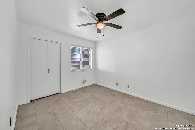 unfurnished bedroom featuring ceiling fan and a closet