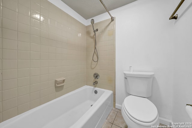 bathroom featuring tile patterned flooring, tiled shower / bath combo, and toilet